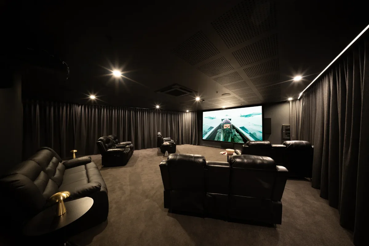 ONE Apartments, Newcastle: private cinema room with black leather recliners facing a large screen