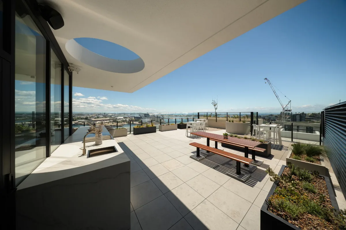 ONE Apartments, Newcastle: rooftop terrace with an outdoor kitchen, timber picnic table and harbour views